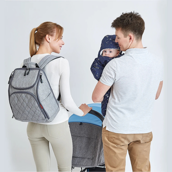 vater traegt grauen wickelrucksack beim spaziergang