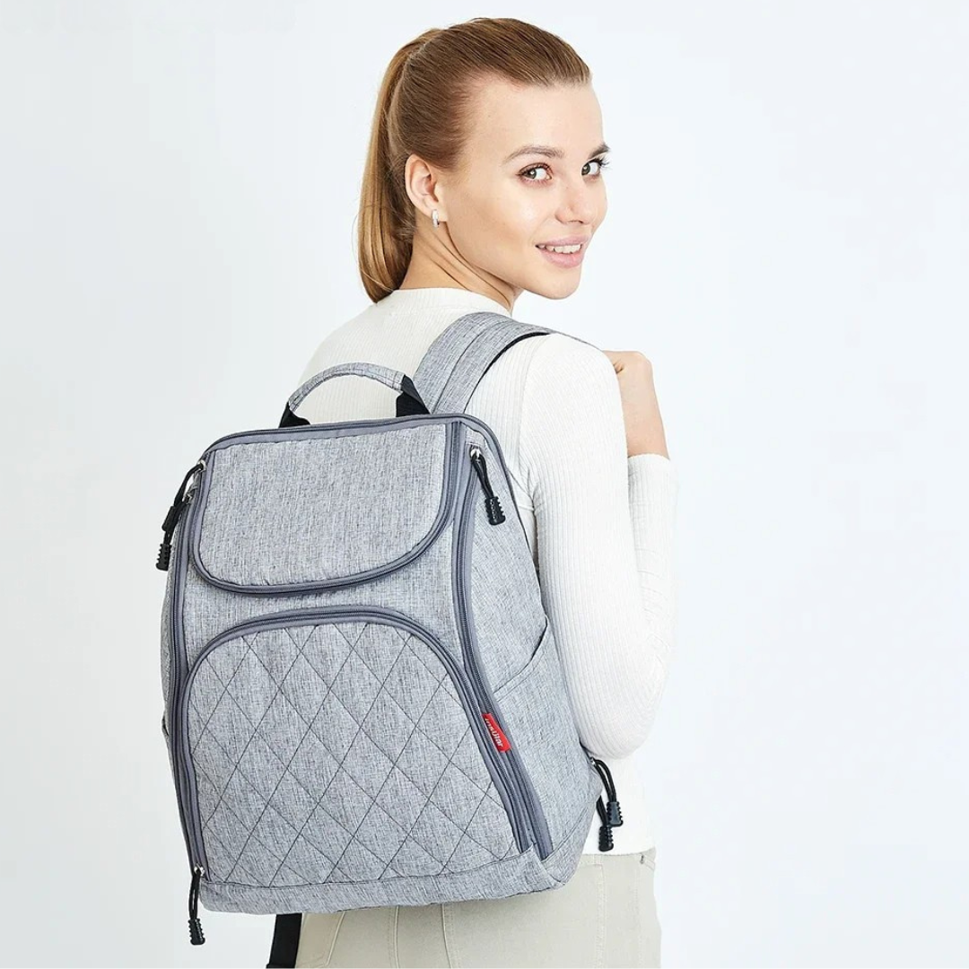 frau zeigt grauen rucksack in studioaufnahme