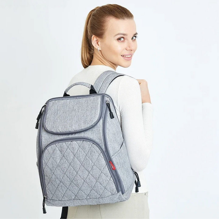 frau zeigt grauen rucksack in studioaufnahme