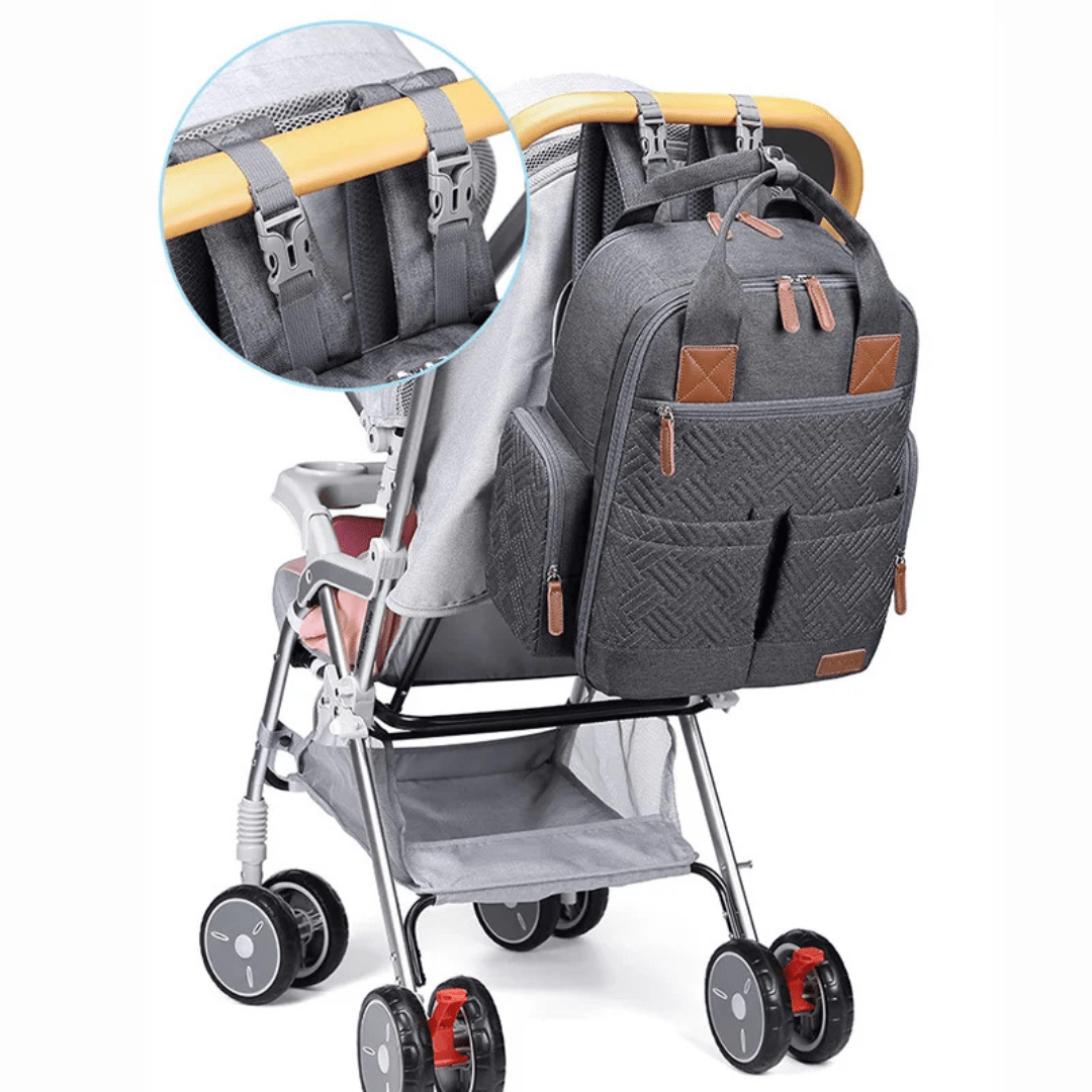 grauer wickelrucksack an kinderwagen befestigt