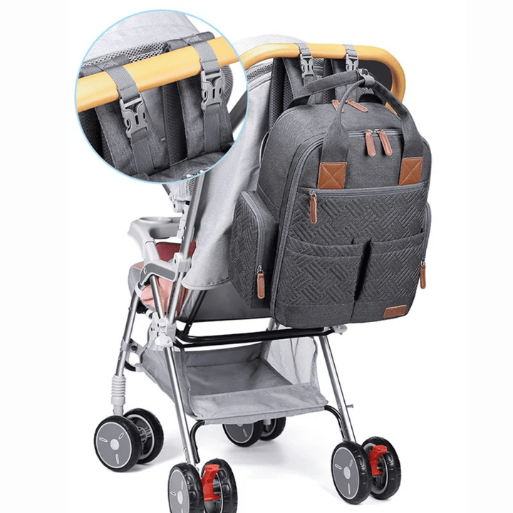 grauer wickelrucksack an kinderwagen befestigt