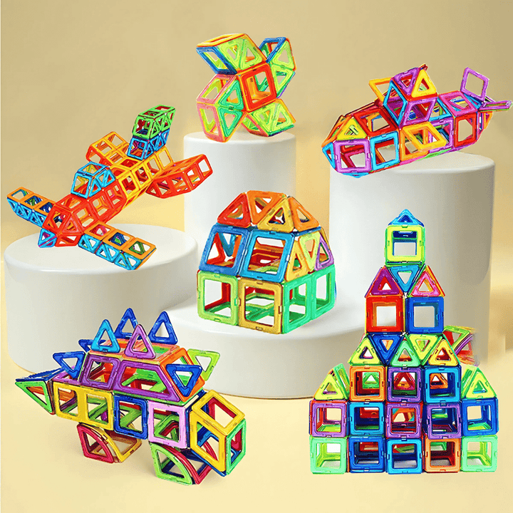 Mehrere bunte Magnet­baustein-Modelle – Flugzeug, Rakete & Häuser auf Podesten