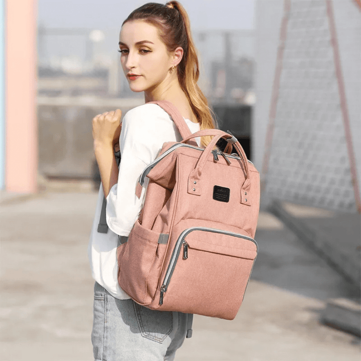 frau traegt rosa wickelrucksack unterwegs