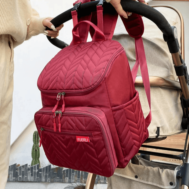 bordeauxroter wickelrucksack an kinderwagen
